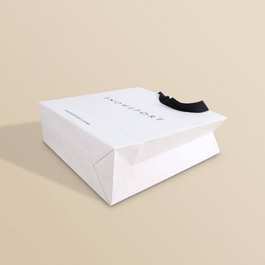White paper shopping bag with black ribbon handles, logo printed on top