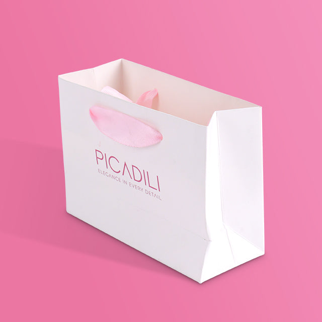 White paper tote bag with PICADILI logo and pink ribbon handle