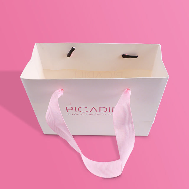 White paper tote bag open top with pink ribbon handles, PICADILI logo