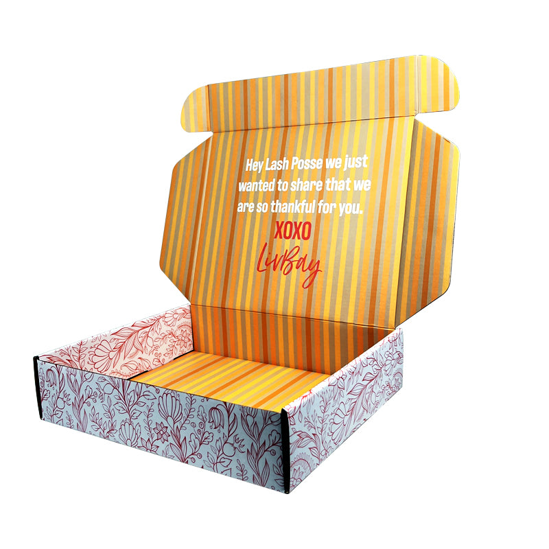 Mailer box with open lid, orange striped interior and pink leaf print on sides