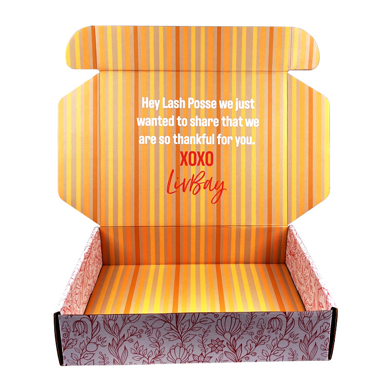 Mailer box with open lid, orange striped interior and burgundy leaf-pattern base