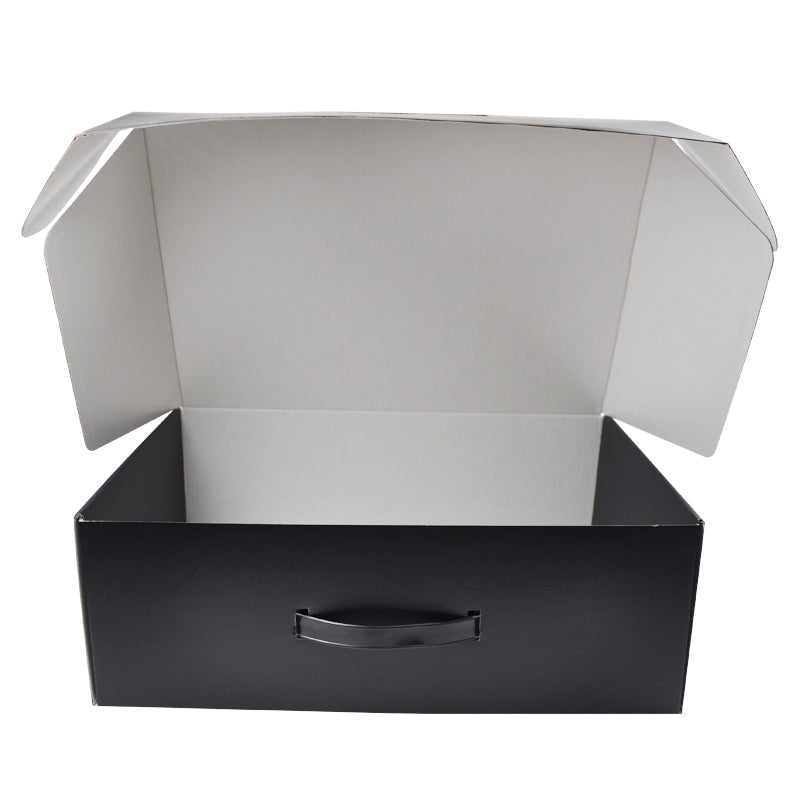 Open black corrugated mailer box with handle hole, empty interior.