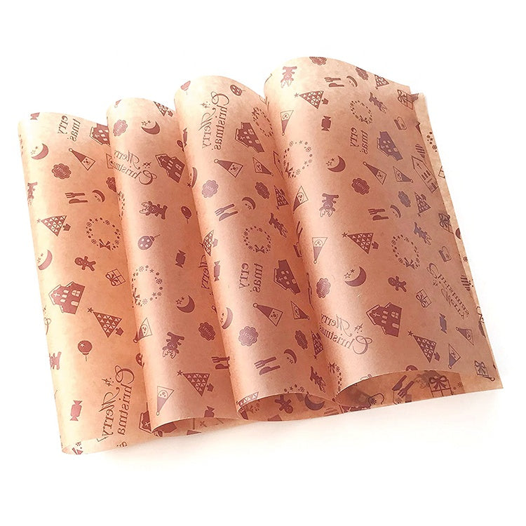 Pink wax paper with small holiday icons and text, folded sheet stack for wrapping