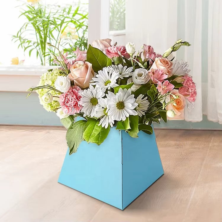 Blue trapezoid floral arrangement box placed on a wooden floor