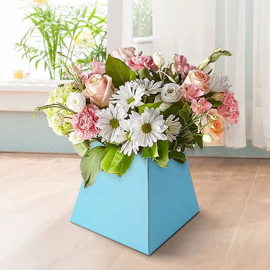 Blue trapezoid floral arrangement box placed on a wooden floor