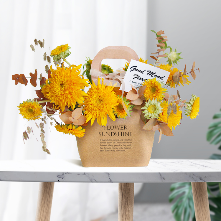 Kraft paper flower basket bag with "Flower Sunshine" print holding yellow chrysanthemums