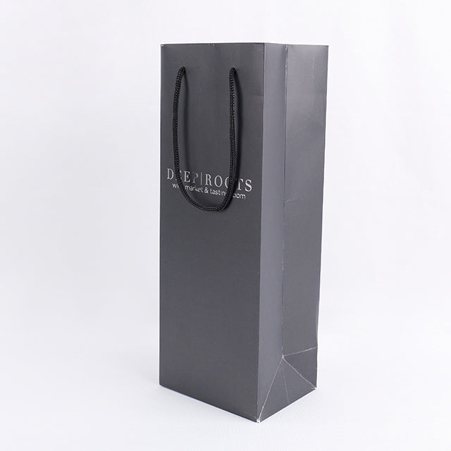 Black paper gift bag with twin rope handles and 'DEEP ROOTS' logo on front