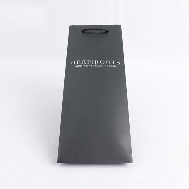 Black paper wine gift bag with rope handle and 'DEEP ROOTS' logo on front