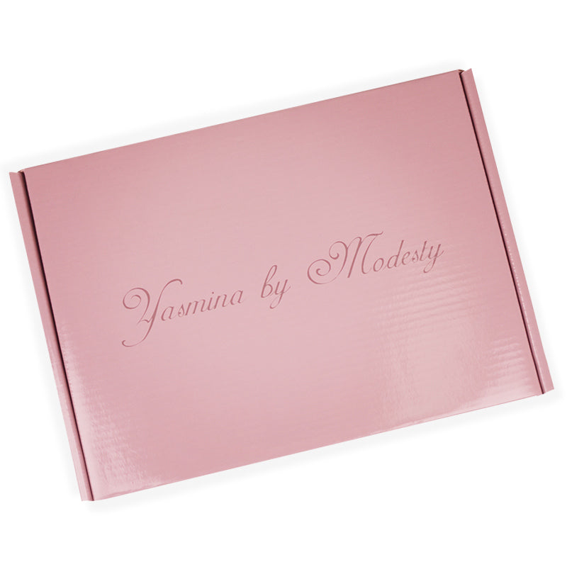 Angled view of pink rigid box showing spine and cursive brand name printing