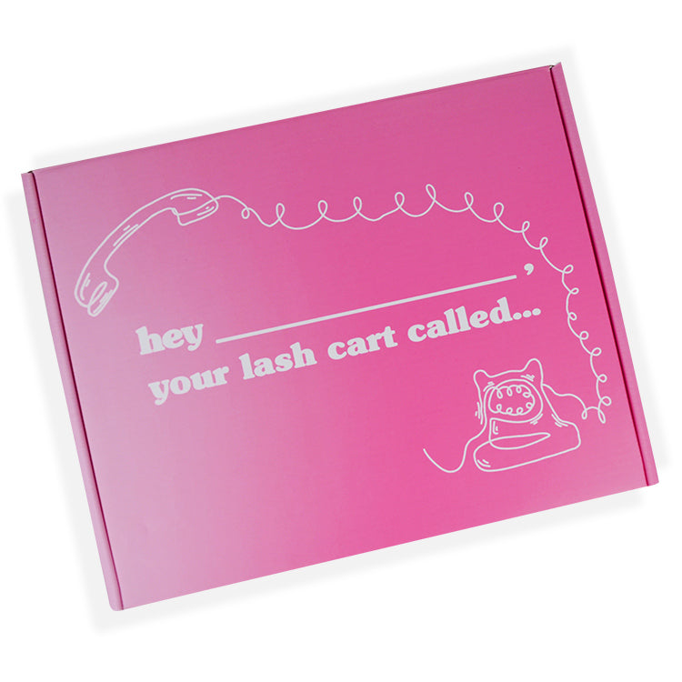Front view of pink eyelash mailer box with "hey your lash cart called" slogan and phone graphic