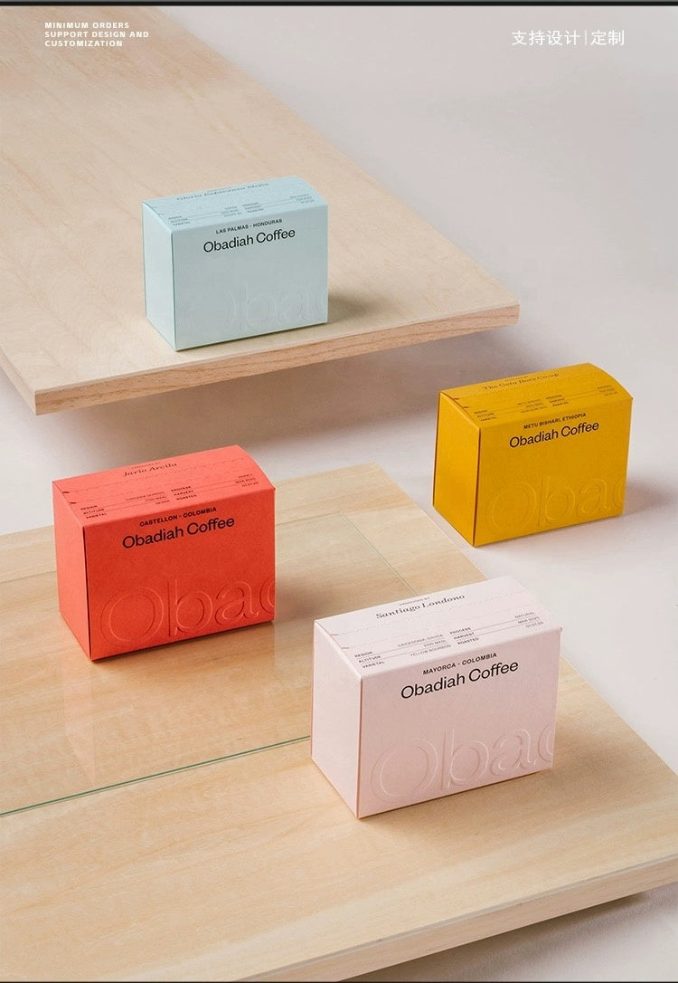 Printed tear-apart slide-lid coffee packaging boxes in red, yellow, blue, and white