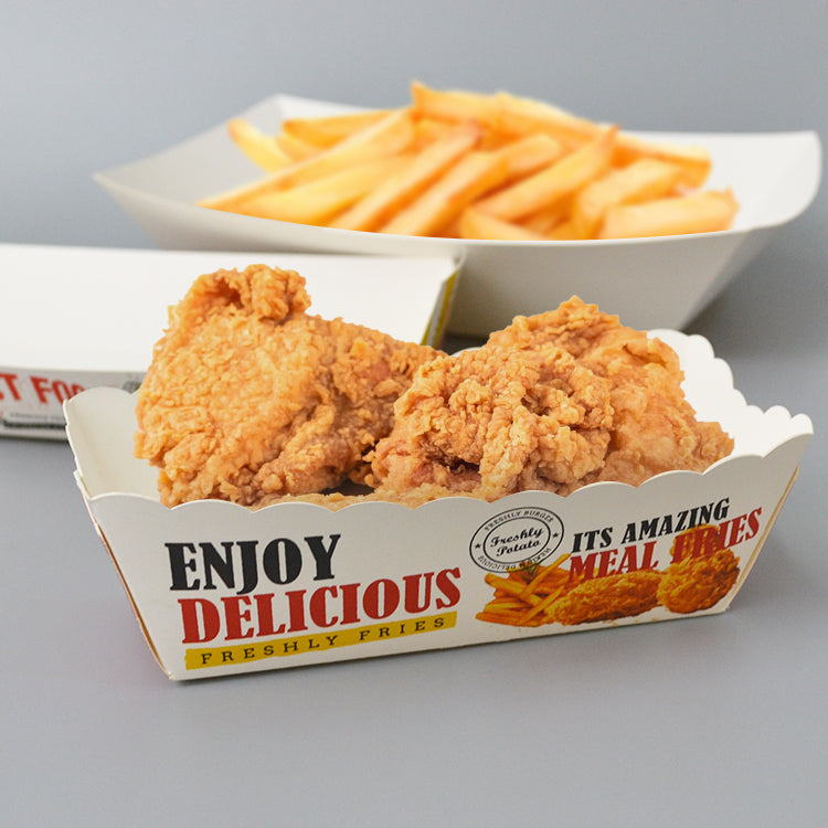 White scalloped edge paper boat tray holding fried chicken with "Enjoy Delicious" print