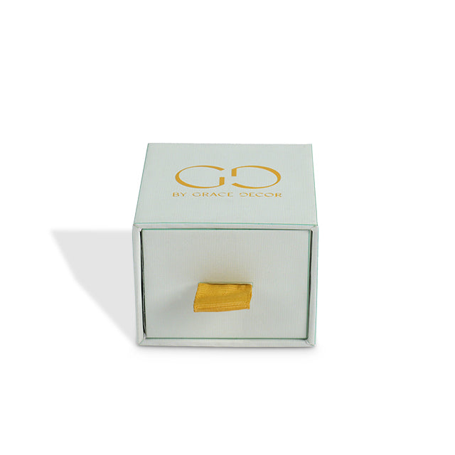	
Front view of closed drawer box featuring a golden ribbon pull tab and gold stripes
