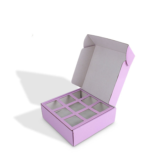 Open purple mailer box revealing 9-compartment cardboard insert for treats