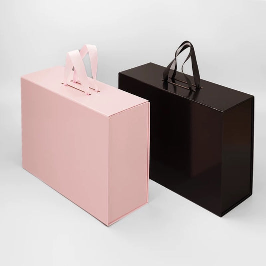 Pink and black foldable gift boxes with ribbon handles, shown side by side