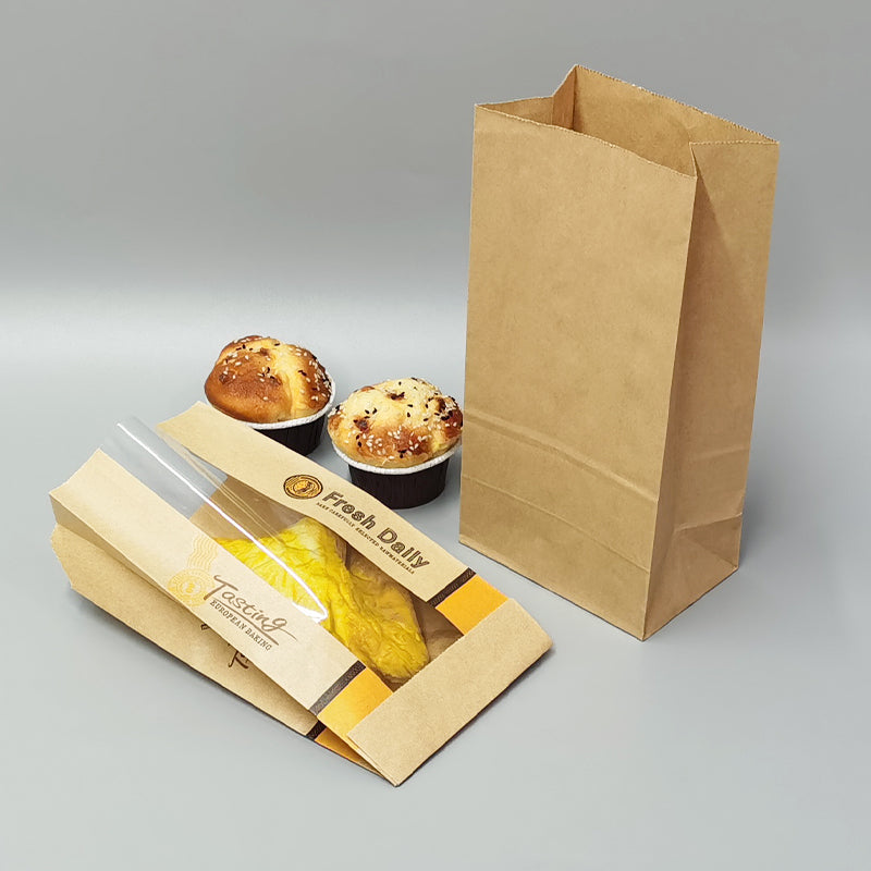 Kraft bakery paper bags with handles, upright and stacked, printed Sunshine Bakery branding