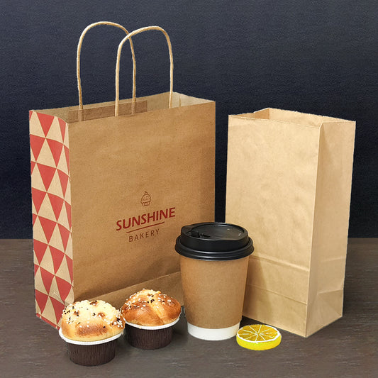 Kraft brown paper bakery bags with gold string handles and Sunshine Bakery logo